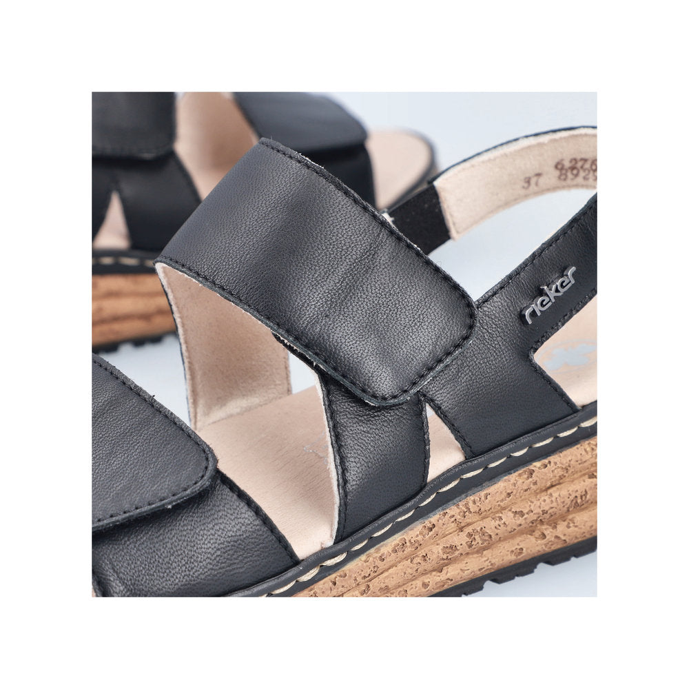 Rieker 62761-00 women's black leather touch fastening sandals with cork-embellished sole and adjustable straps.