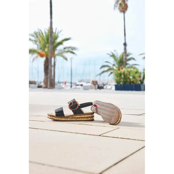 Rieker 62950-14 Ladies Pacific Blue Touch Fastening Sandals on a tiled walkway with palm trees and marina in background.
