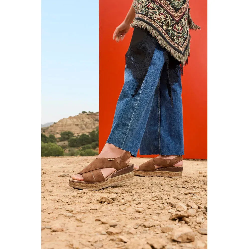 Rieker 63782-24 ladies brown elasticated sandals with cushioned soles, worn with wide-leg jeans in a desert landscape.