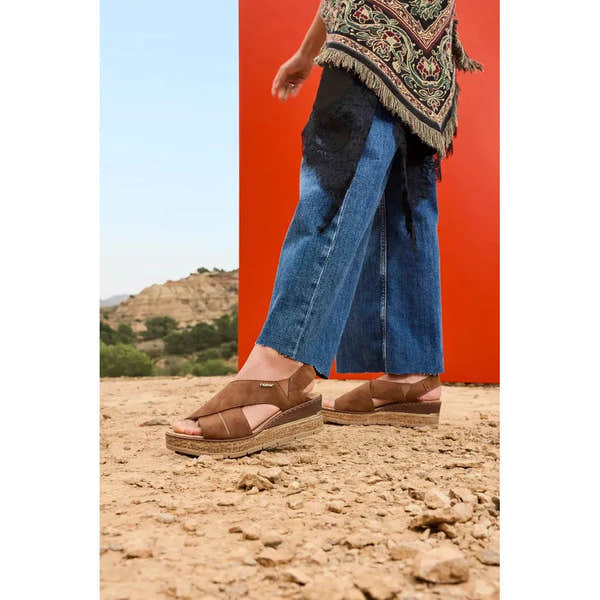 Rieker 63782-24 ladies brown elasticated sandals with cushioned soles, worn with wide-leg jeans in a desert landscape.