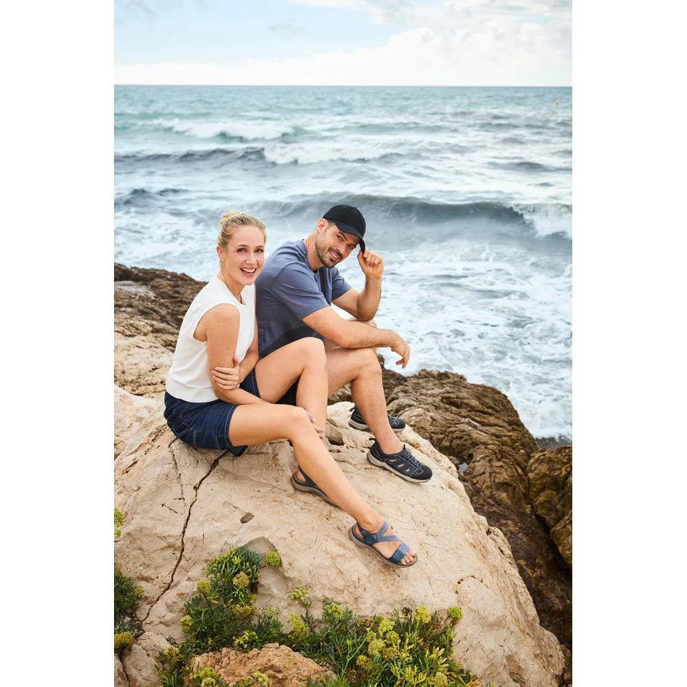 Rieker 64870-14 Ladies BlueTouch Velcro Sandals worn by a woman, displayed outdoors near the ocean.