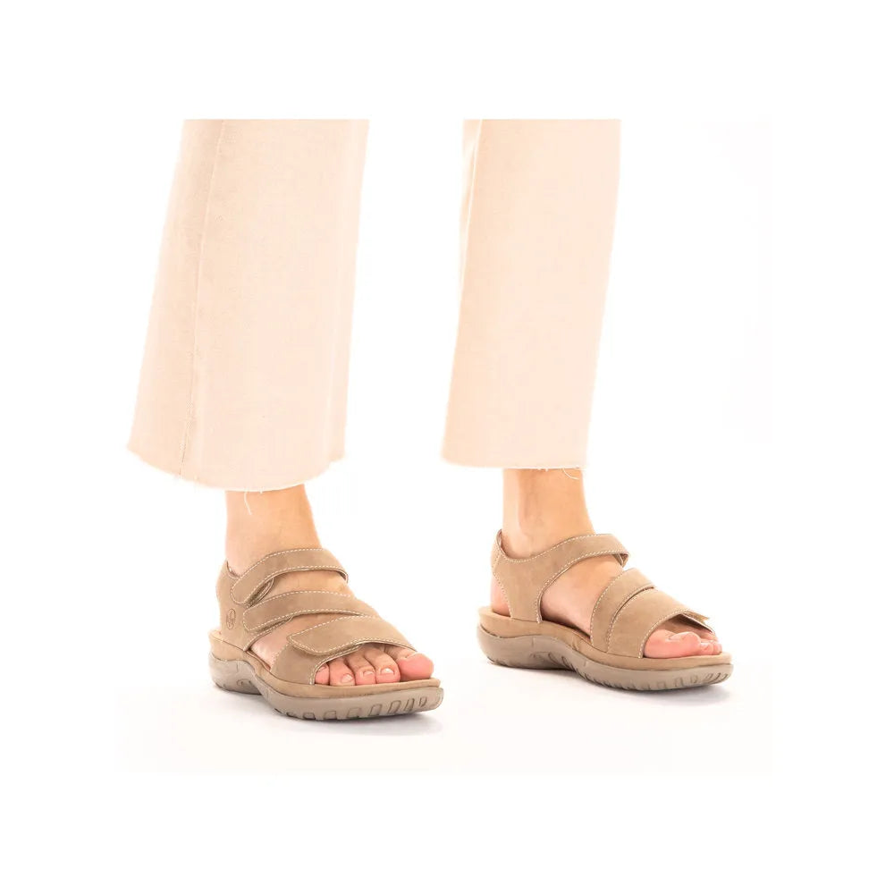 Beige and white touch fastening sandals with two adjustable straps and comfortable soles, paired with light trousers.
