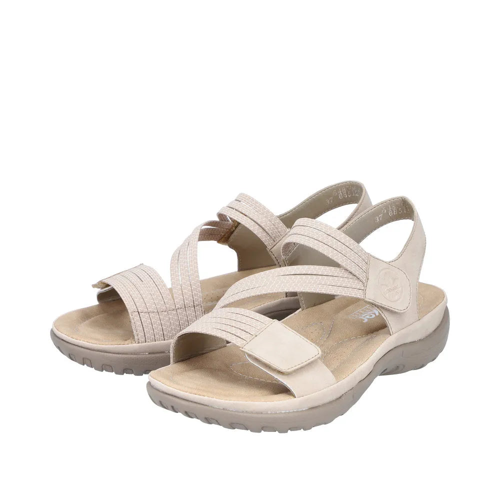 Beige and white Rieker ladies' sandals with touch fastening, featuring textured straps and cushioned footbed for comfort.