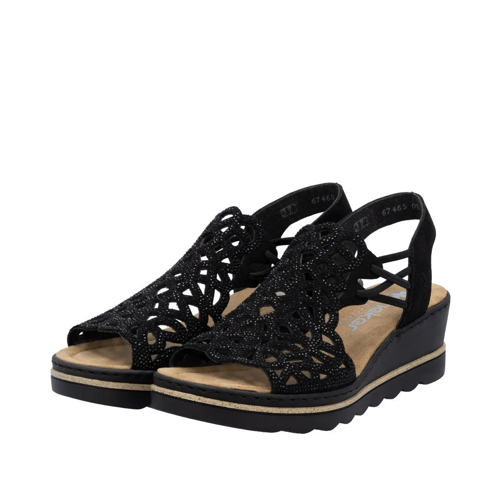 Rieker 67465-00 women's black textile elasticated open-toe sandals with intricate cutout design and wedge heel.