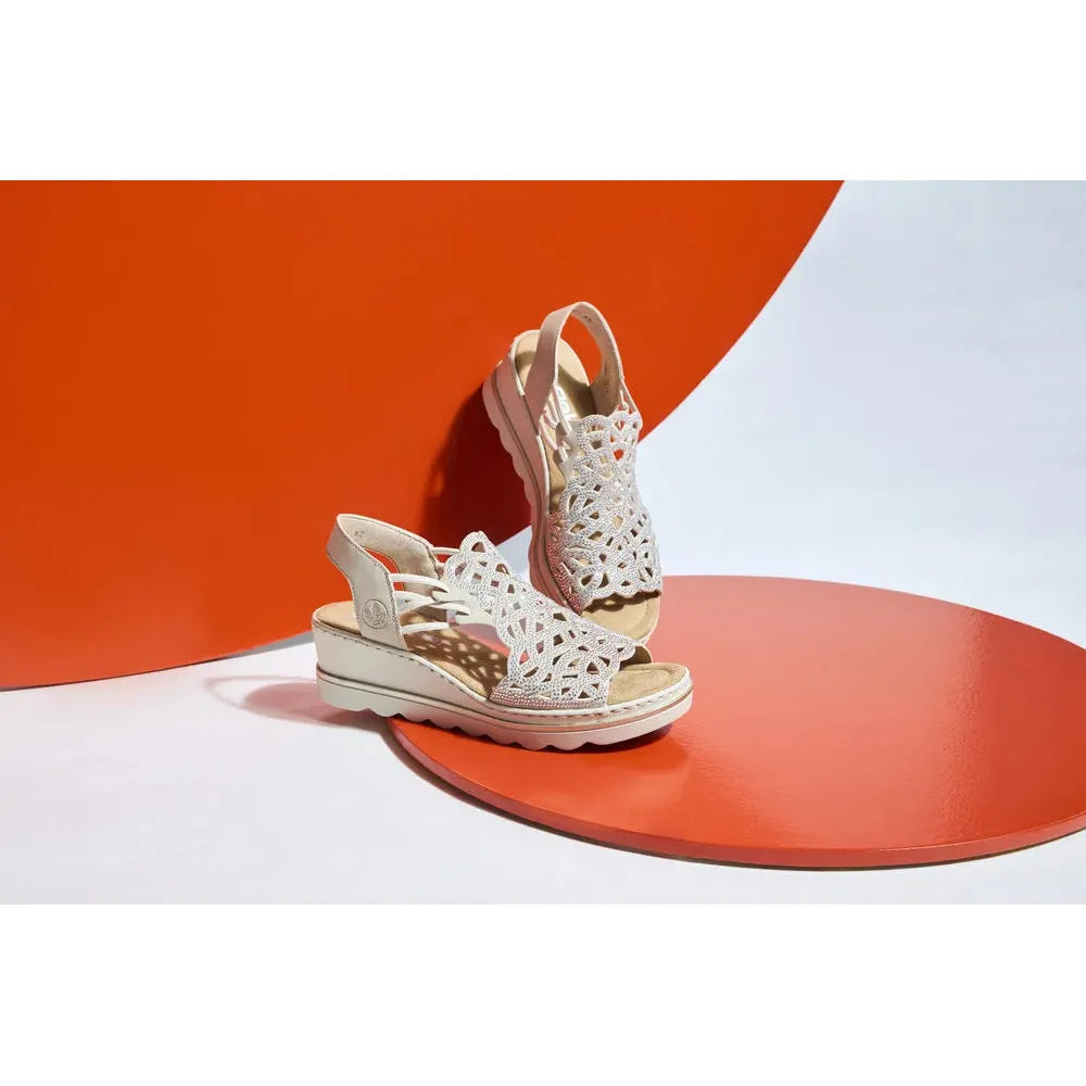 Rieker 67465-62 Ladies Beige Elasticated Sandals with cut-out design and wedge heel on orange and white background.