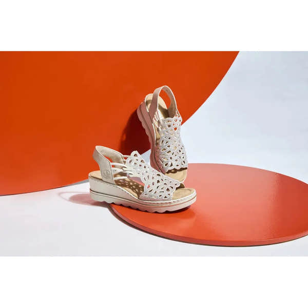 Rieker 67465-62 Ladies Beige Elasticated Sandals with cut-out design and wedge heel on orange and white background.