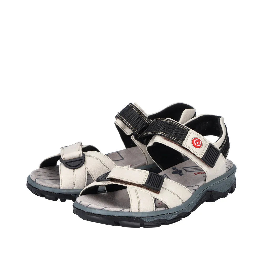 Rieker 68851-80 women's ivory touch-fastening sandals with adjustable straps and rugged black soles.