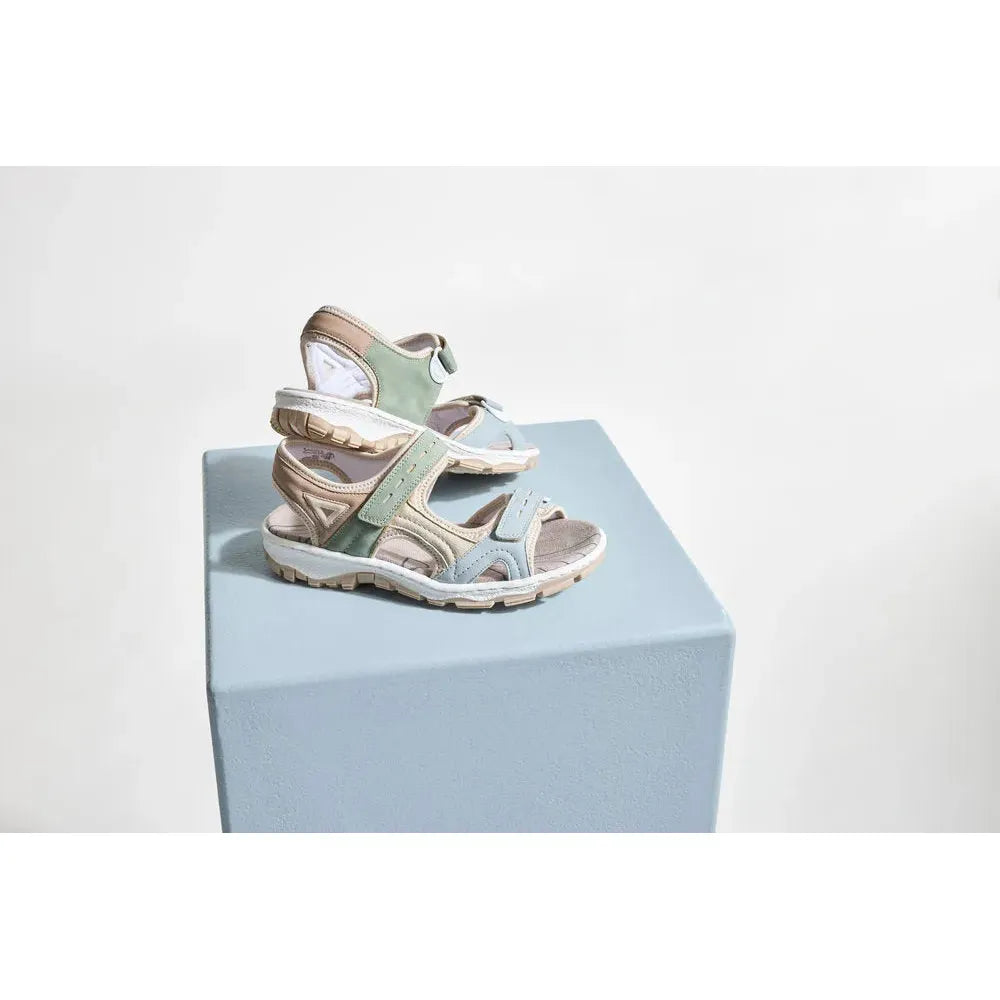 Rieker 68866-94 women's multi-touch fastening sandals in pastel green, beige, and light blue on light blue display stand.