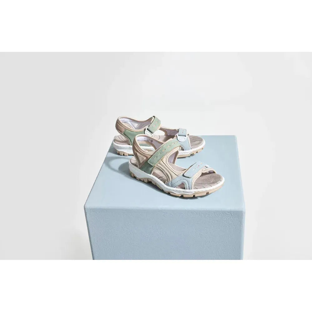 Rieker 68866-94 women's multi-touch fastening sandals with beige, pastel blue, and green straps on a light blue pedestal.