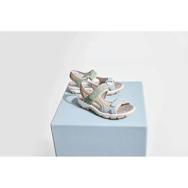 Rieker 68866-94 women's multi-touch fastening sandals with beige, pastel blue, and green straps on a light blue pedestal.