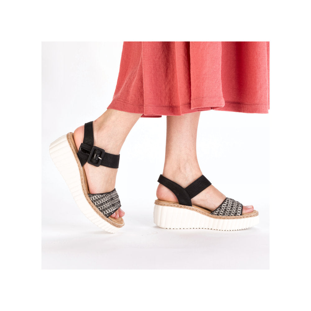 Rieker 69176-00 women's black buckle sandals with woven straps and platform sole.