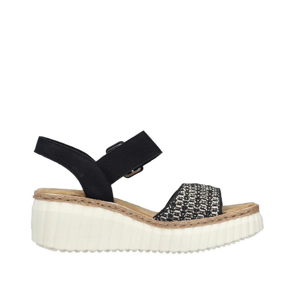 Rieker 69176-00 women's black buckle sandals with patterned strap, cushioned sole, and chunky white platform outsole.