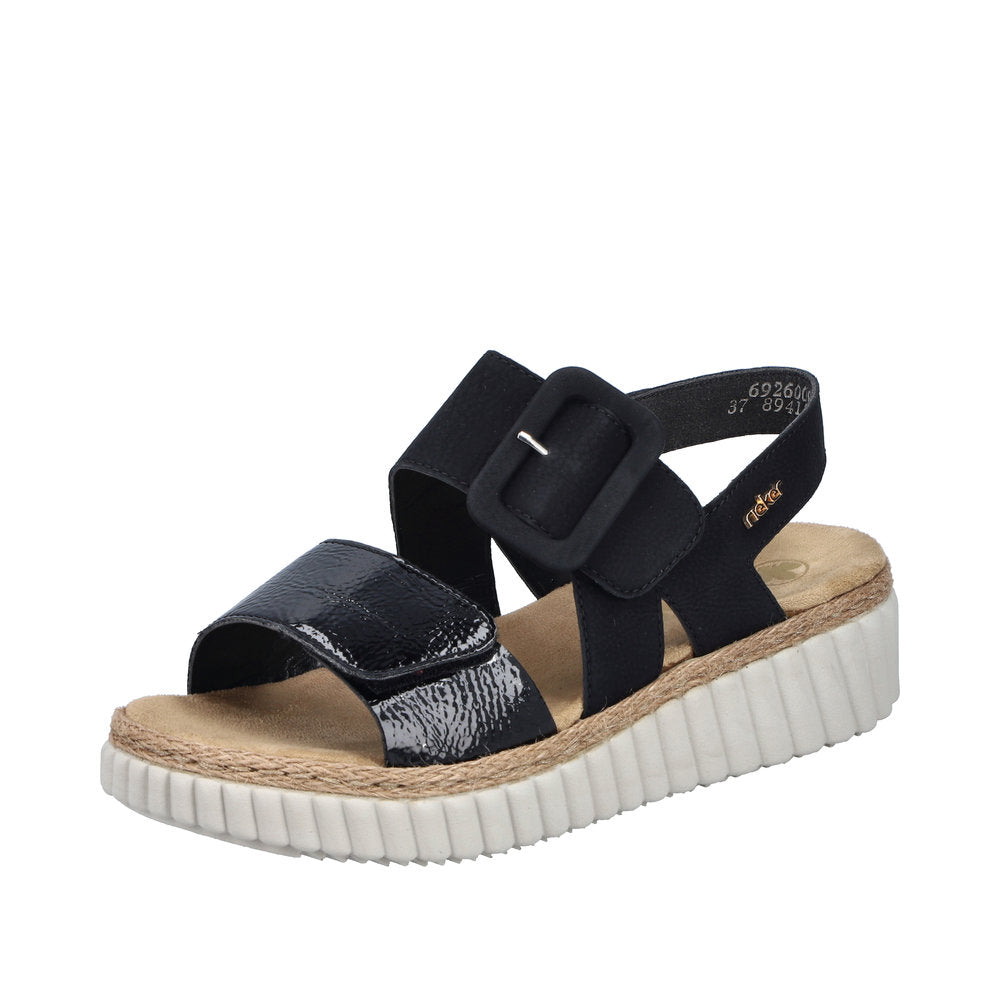 Rieker 69260-00 women's wide black buckle sandal with textured strap, cushioned insole, and white platform sole.