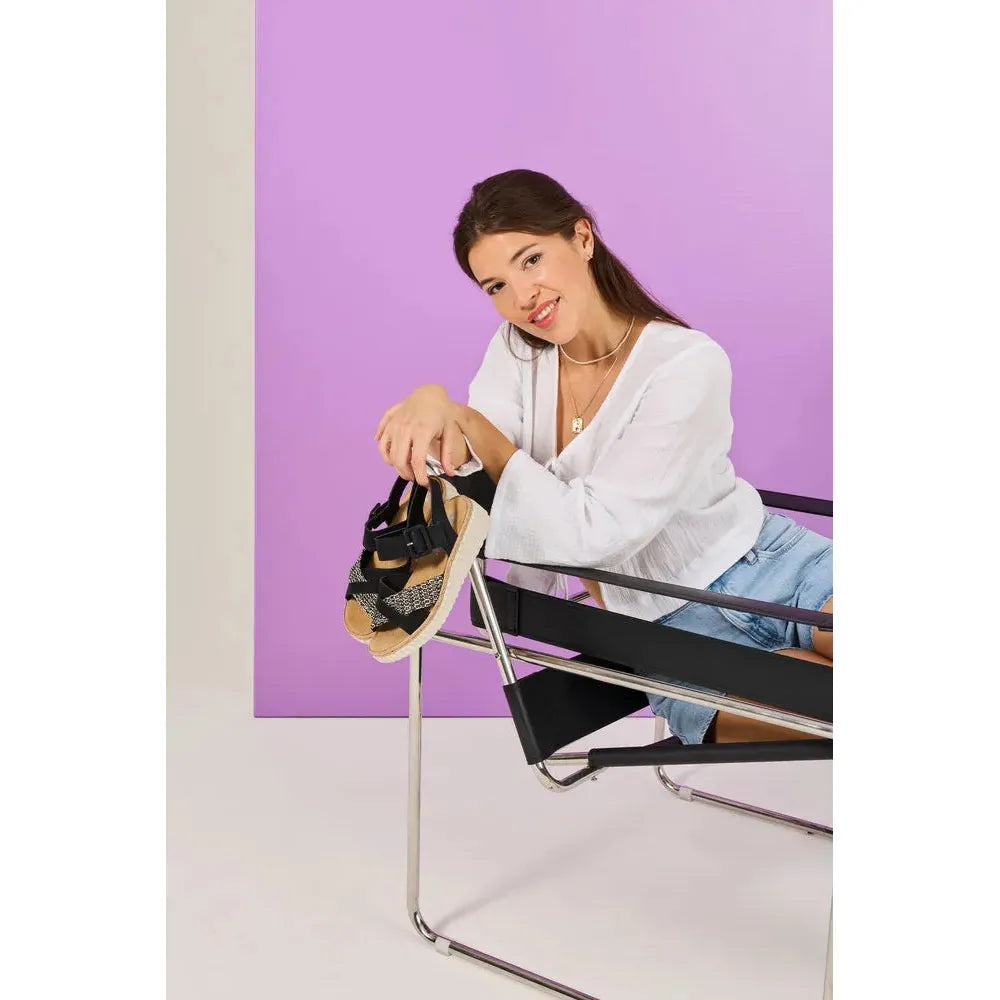 Rieker 69269-00 women's wide black touch fastening sandals, stylish and comfortable footwear, on a model with a purple background.