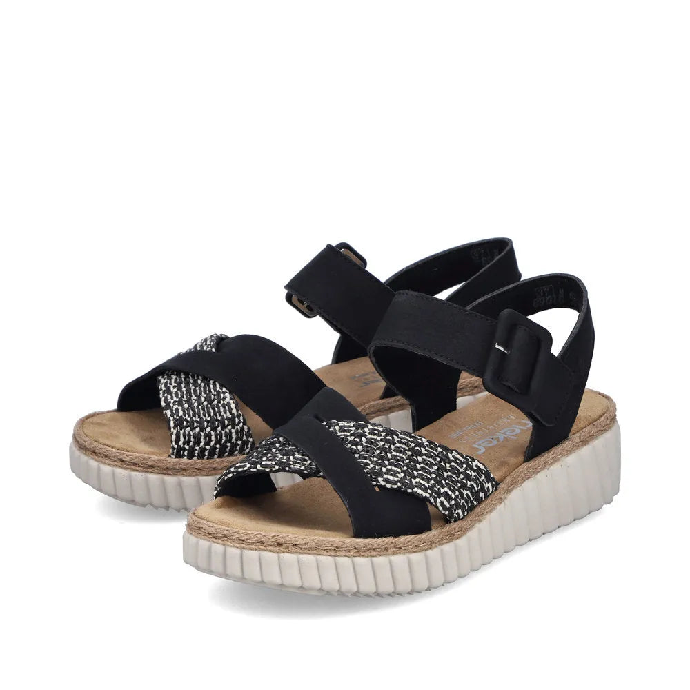Rieker 69269-00 women's wide black touch fastening sandals with patterned and plain straps, cushioned footbed, and chunky white sole.