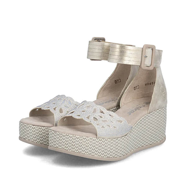 Rieker 69457-60 women's beige buckle wedge sandals with decorative cut-out strap and textured platform sole.