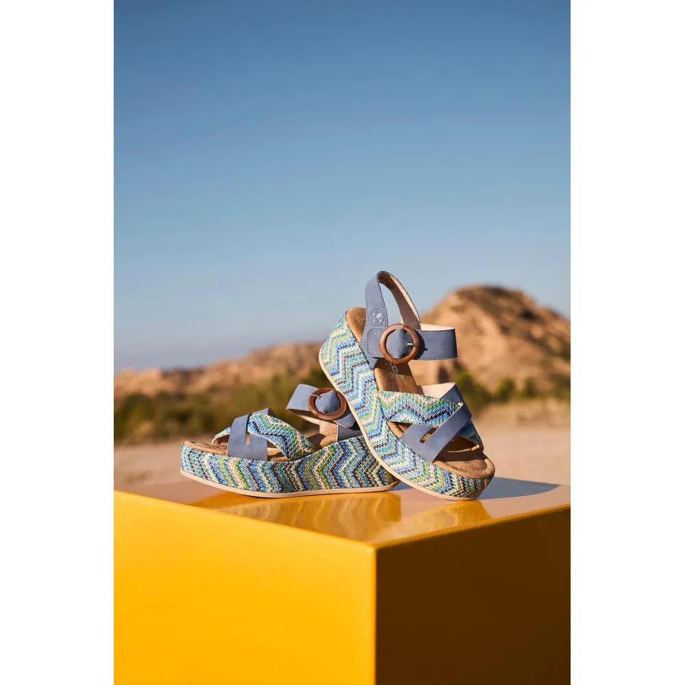 Rieker 69469-14 women's navy touch fastening sandals with zigzag patterned straps, buckles, and cushioned soles, outdoor sandy background.