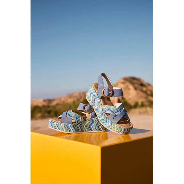 Rieker 69469-14 women's navy touch fastening sandals with zigzag patterned straps, buckles, and cushioned soles, outdoor sandy background.