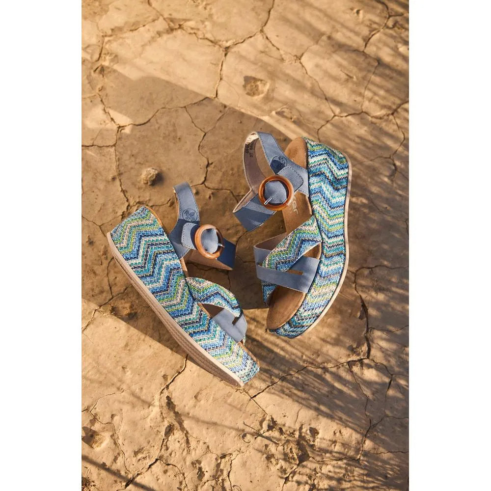 Rieker 69469-14 ladies navy touch fastening sandals with colorful zigzag patterned straps on cracked desert ground.