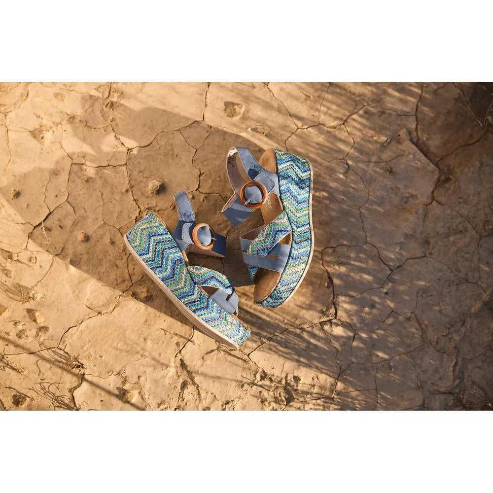 Rieker 69469-14 navy touch fastening ladies' sandals with zigzag patterned straps and round buckle on dry, cracked earth.