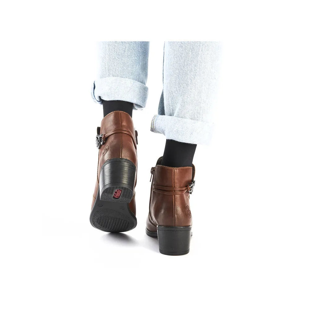 Rieker 73970-22 women's brown ankle boots with side zippers, chunky heels, and black socks, stylish and comfortable for fall wear.
