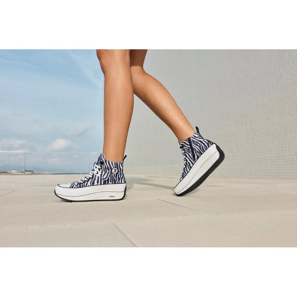 Women's zebra print vegan ankle boots with textile material, zip and lace-up detail, chunky sole, and black and white color.