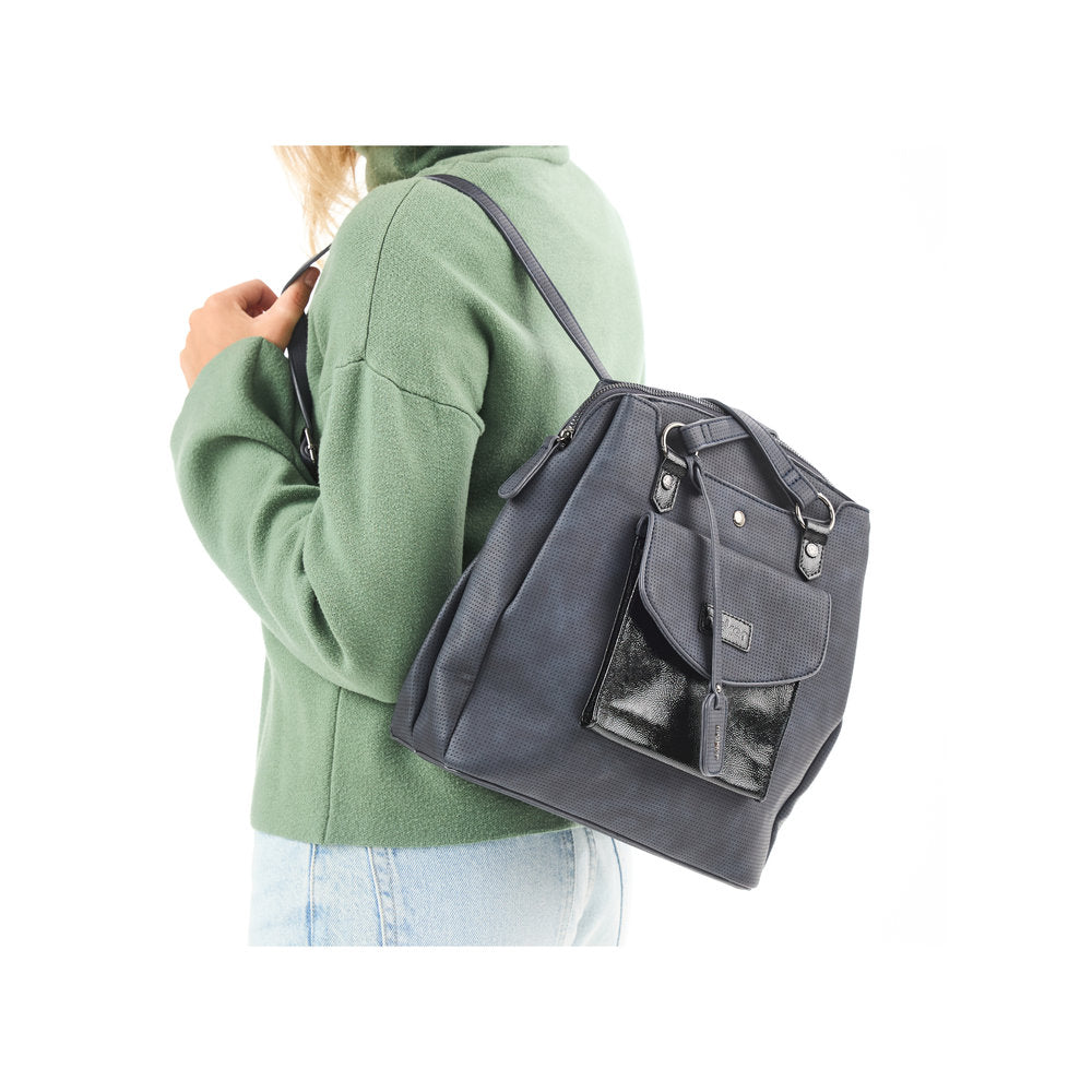 Rieker H1036-14 Ocean Navy & Black backpack with multiple compartments, front pocket, and adjustable strap on a woman in a green sweater.