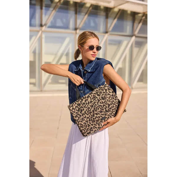 Rieker H1070-90 leopard print handbag, stylish rectangular bag with leopard pattern, carried by woman outdoors with sunglasses.