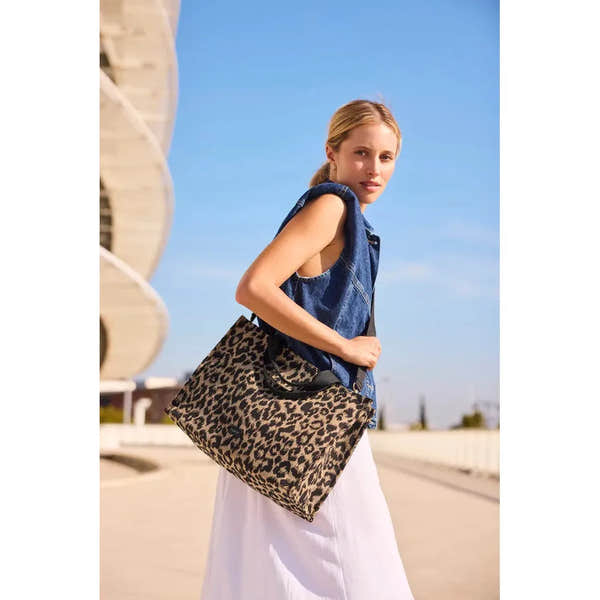 Rieker H1070-90 leopard print handbag with black handles, stylish and spacious for women, outdoor urban setting.