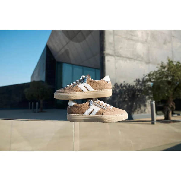 Rieker L5903-20 ladies camel suede sneakers with white accents, zip and lace-up closure, chunky sole, outdoor setting.