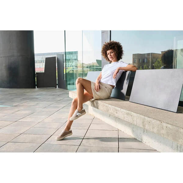 Woman wearing beige suede Rieker L5903-20 zip and lace casual shoes, sitting on a bench outside.
