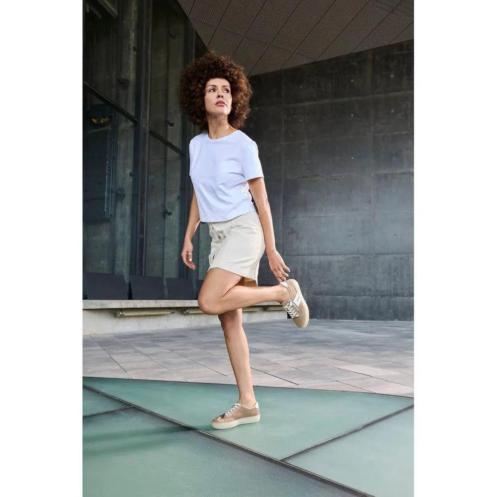 Women’s camel suede lace-up and zip shoes, stylish and casual, worn by a woman with curly hair in an outdoor urban setting.