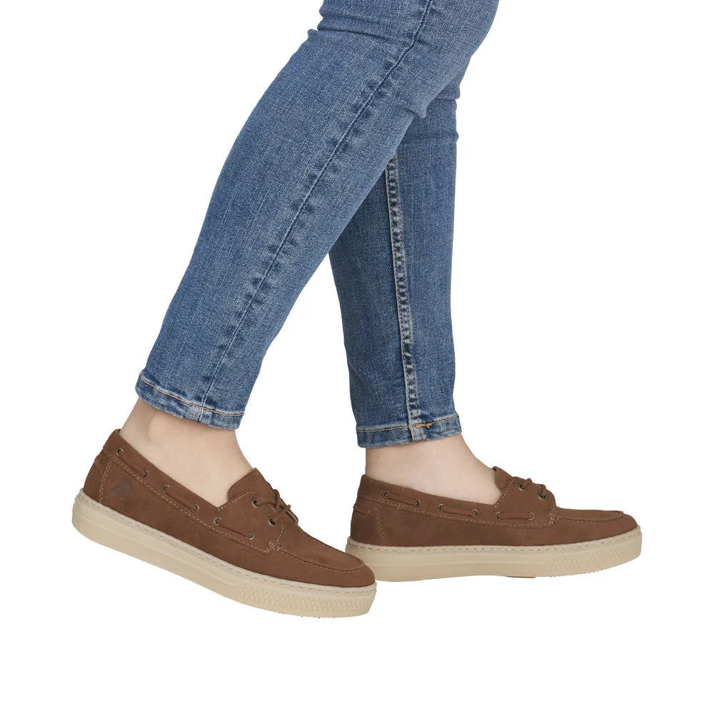 Rieker L5905-24 ladies brown suede slip-on boat shoes with laces and cream sole, styled with blue jeans.