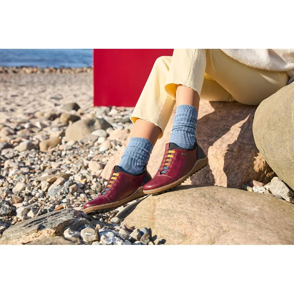 Rieker L7562-35 Ready2Go women's red leather slip-on water-resistant shoes on rocky beach.
