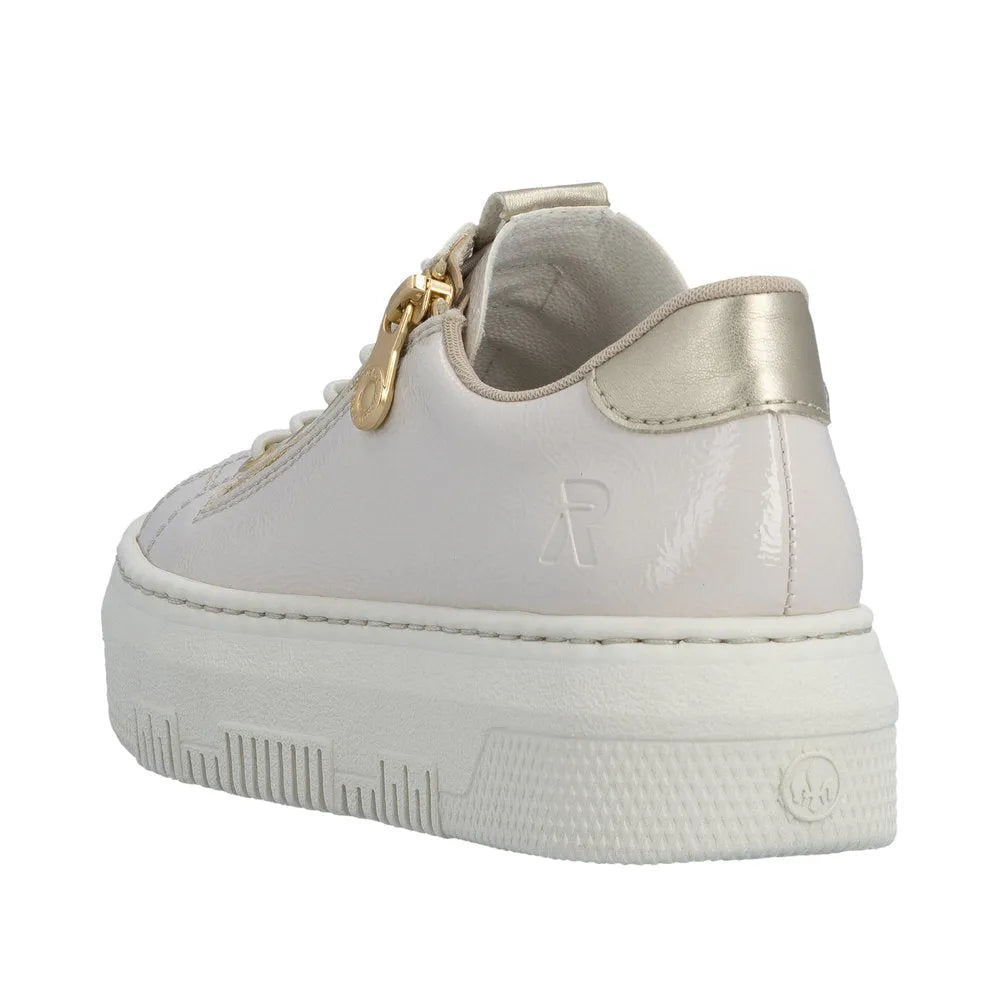 Rieker M1953-80 Ladies off-white patent trainers with side zip and gold accents, chunky sole, and metallic heel detail.