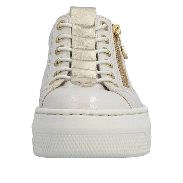 Off-white patent lace-up trainer with side zipper, gold accents, chunky sole, and metallic gold strap detail.