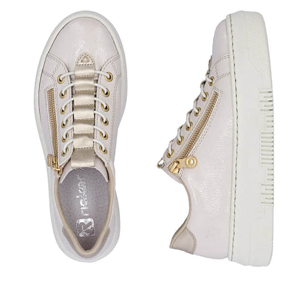 Off-white patent trainers with side gold zipper, lace-up front, and textured sole, featuring gold eyelets and beige accents.
