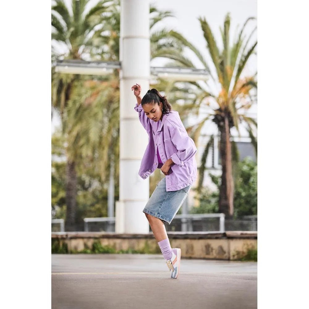 Rieker M5520-91 women's multi zip & lace trainers, casual sneakers with pastel accents, worn by a woman on city street in jeans and purple jacket.