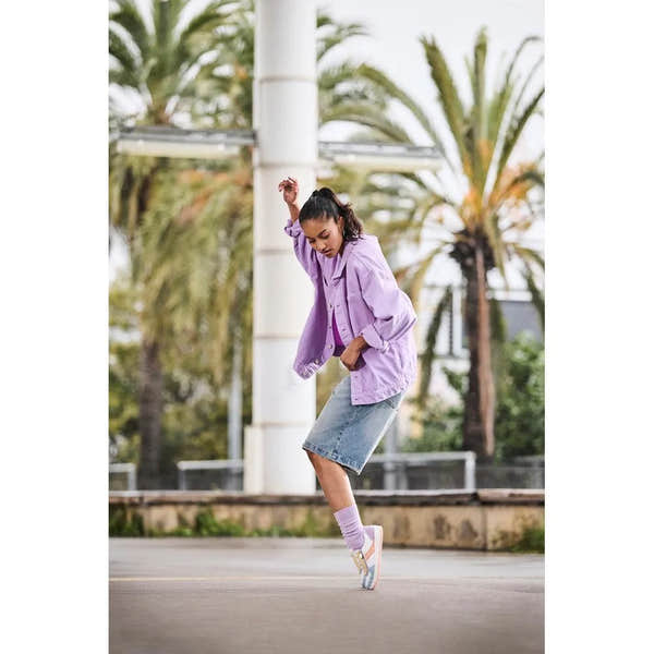 Rieker M5520-91 women's multi zip & lace trainers, casual sneakers with pastel accents, worn by a woman on city street in jeans and purple jacket.