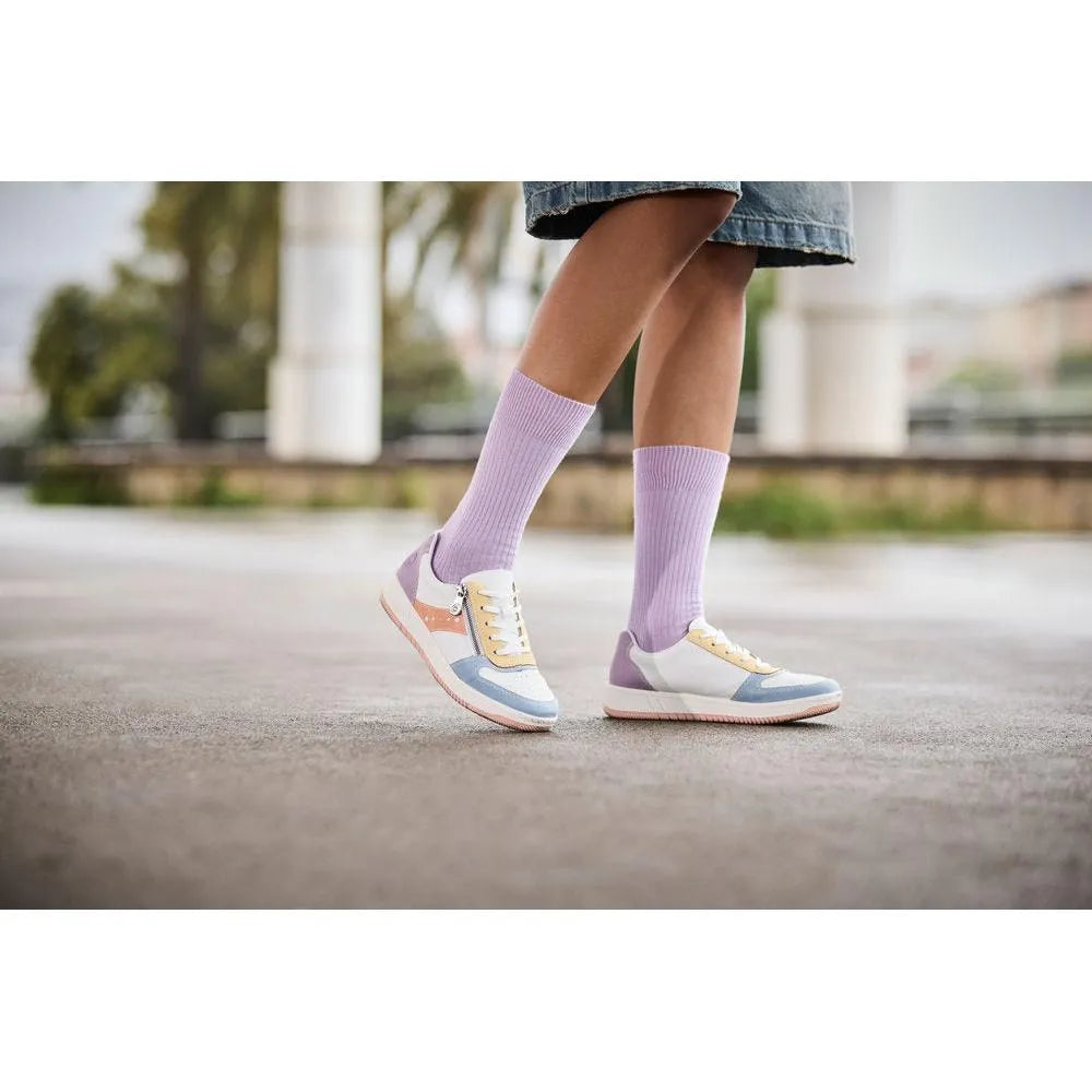 Rieker M5520-91 women’s multi zip & lace trainers with pastel color accents, casual athletic style, worn with purple socks and denim skirt.