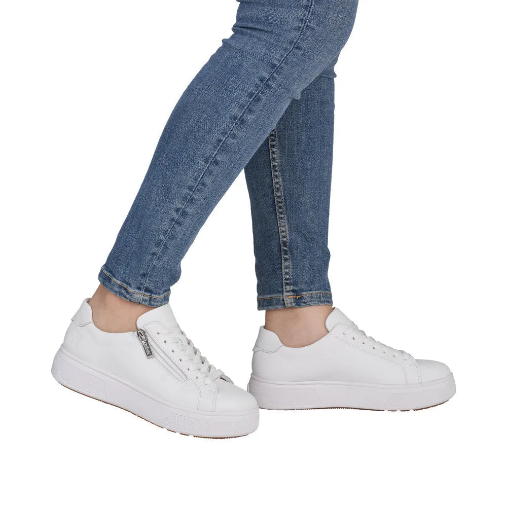 Women’s white leather low-top sneakers with zipper and lace-up closure, chunky sole, and smooth finish.