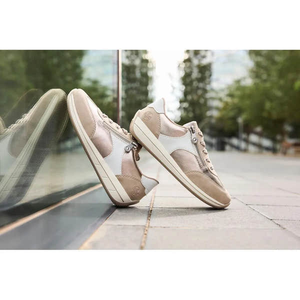 Rieker N1103-90 women's wide white and champagne zip and lace sneakers with beige and white materials, on sidewalk.