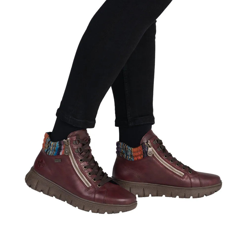 Rieker N1305-35 women's red leather ankle boots with zip, lace-up design, and colorful knit ankle cuffs.
