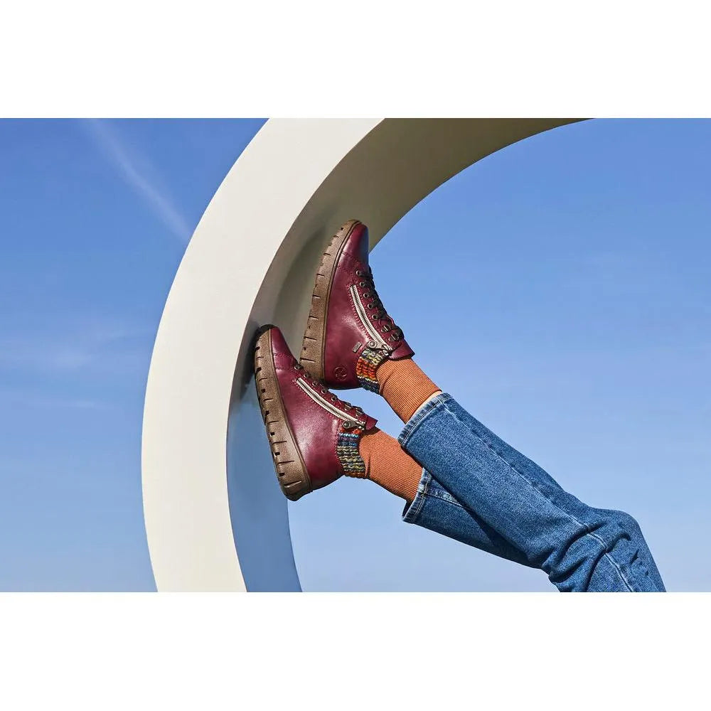 Rieker N1305-35 women's red leather ankle boots with zip and lace-up design, chunky sole, and stylish details.