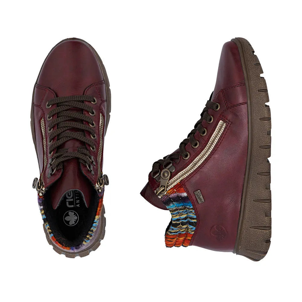 Rieker N1305-35 women's red leather ankle boots with zip and lace-up design, rugged sole, and colorful fabric detail.