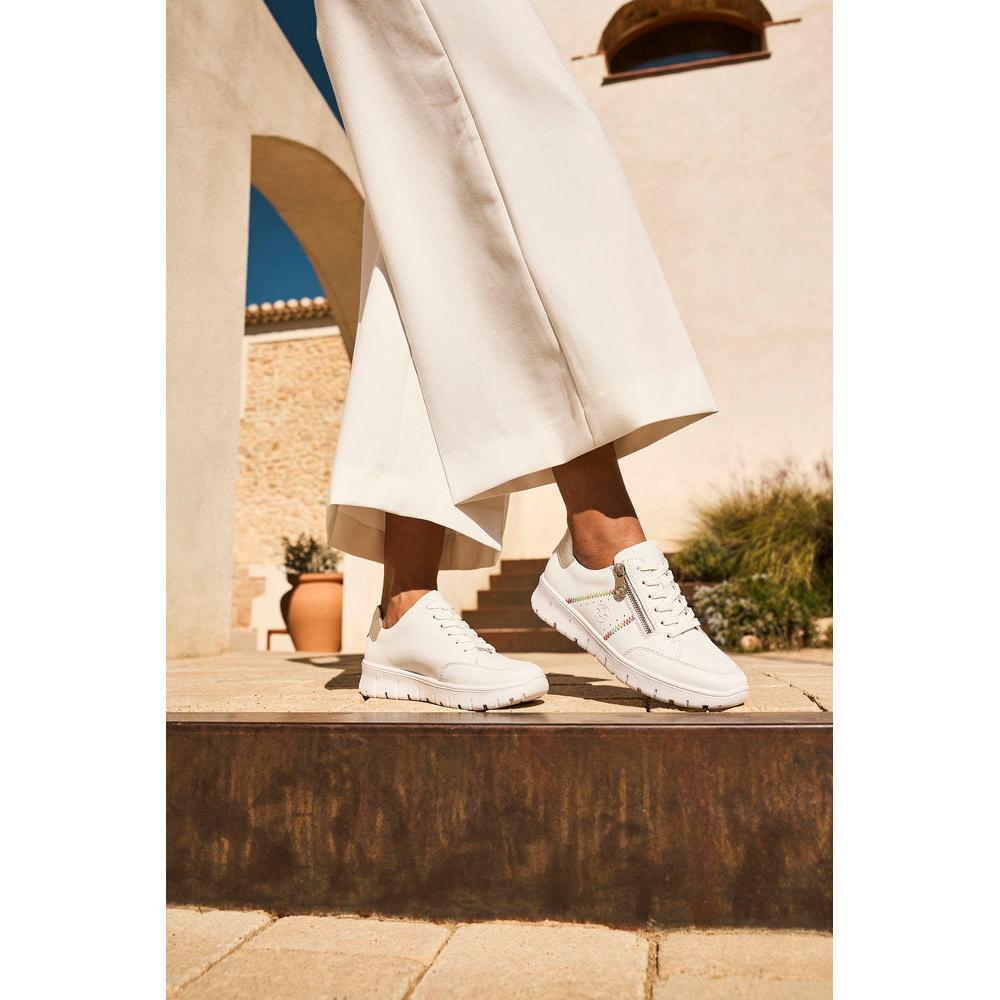Rieker N1313-80 women's wide white leather trainers with zip and lace details, casual sporty style, outdoor setting.