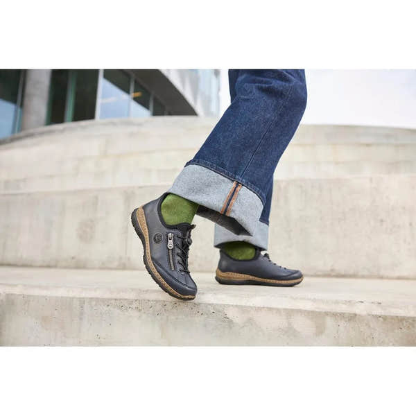 Rieker N3267-15 Ready2Go women's blue slip-on shoes with black accents and textured soles, paired with green socks and rolled-up jeans.