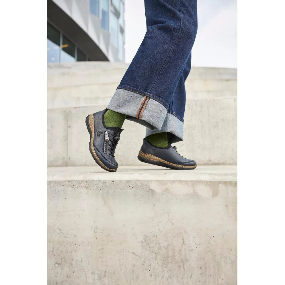 Rieker N3267-15 Ready2Go women's blue slip-on shoes with black detailing, paired with green socks and rolled-up denim jeans.