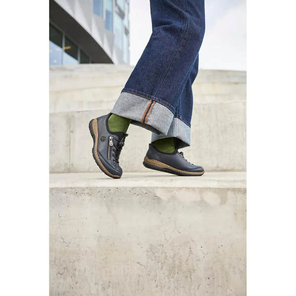 Rieker N3267-15 Ready2Go women's blue slip-on shoes with black detailing, paired with green socks and rolled-up denim jeans.