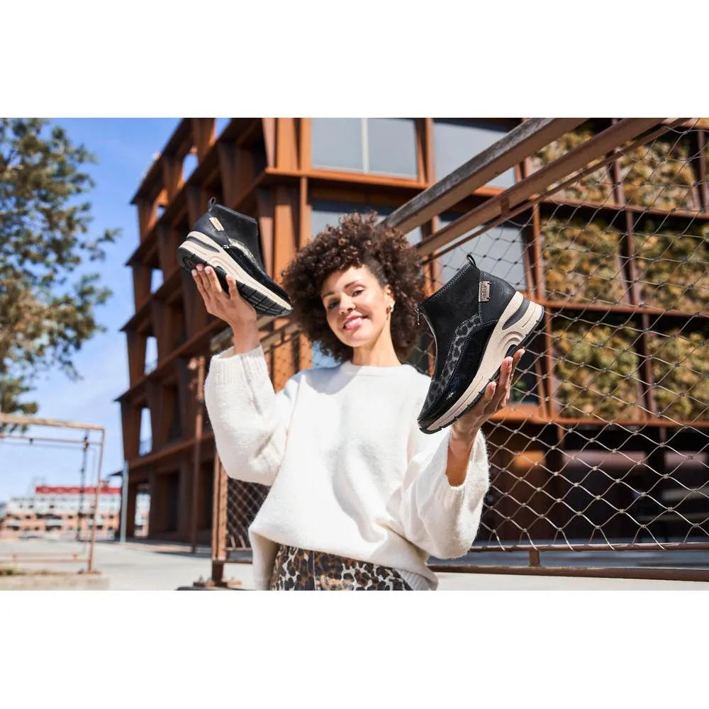 Women’s black and beige Rieker N9362-00 ankle boots with textile front, zip closure, chunky sole, fashionable design.